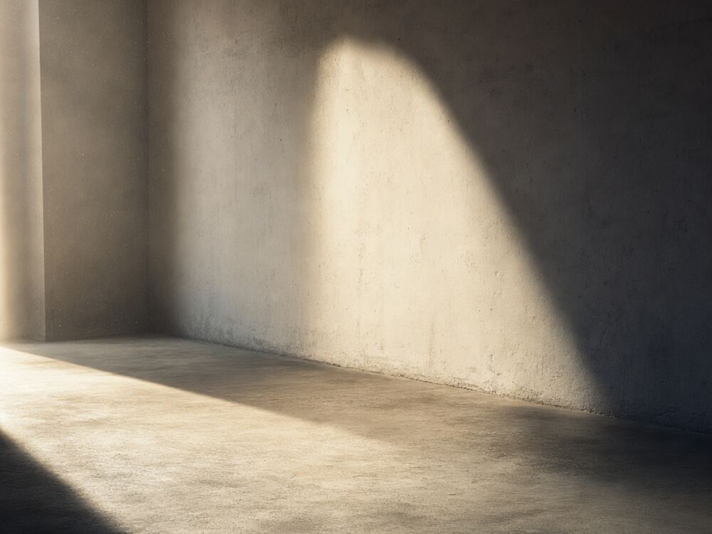 Interior vacío con un haz de luz cruzando el suelo de hormigón.